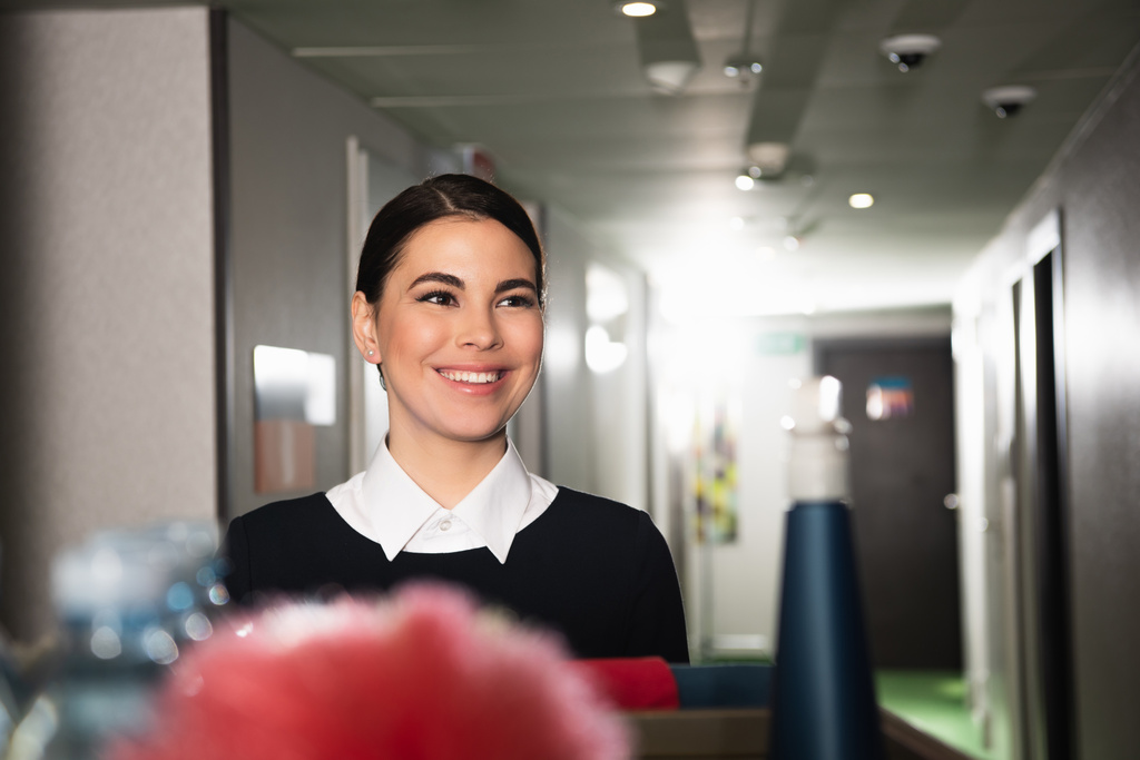 stock-photo-cheerful-maid-blurred-housekeeping-cart